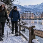 Que visiter en Haute Savoie en hiver : couple sur le lac d’Annecy enneigé, fumée de froid et sommets
